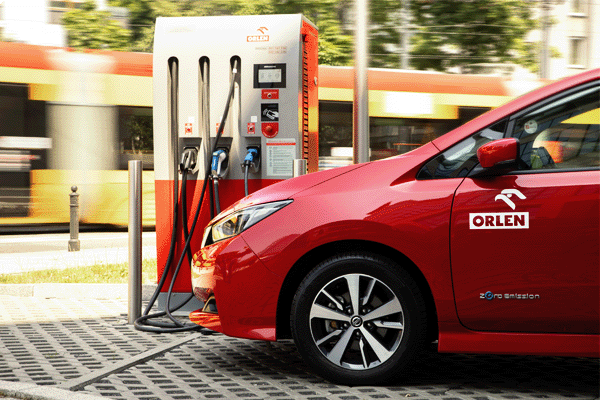 czerwony samochód elektryczny ładuje się na stacji ładowania ORLEN Charge