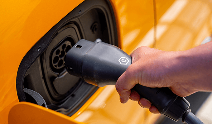 Osoba ładująca samochóch elektryczny